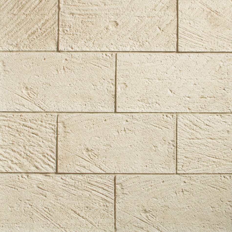 A close-up of beige, textured, rectangular-shaped stone veneer mimicking the look of natural stone in the shade Sand Dollar.