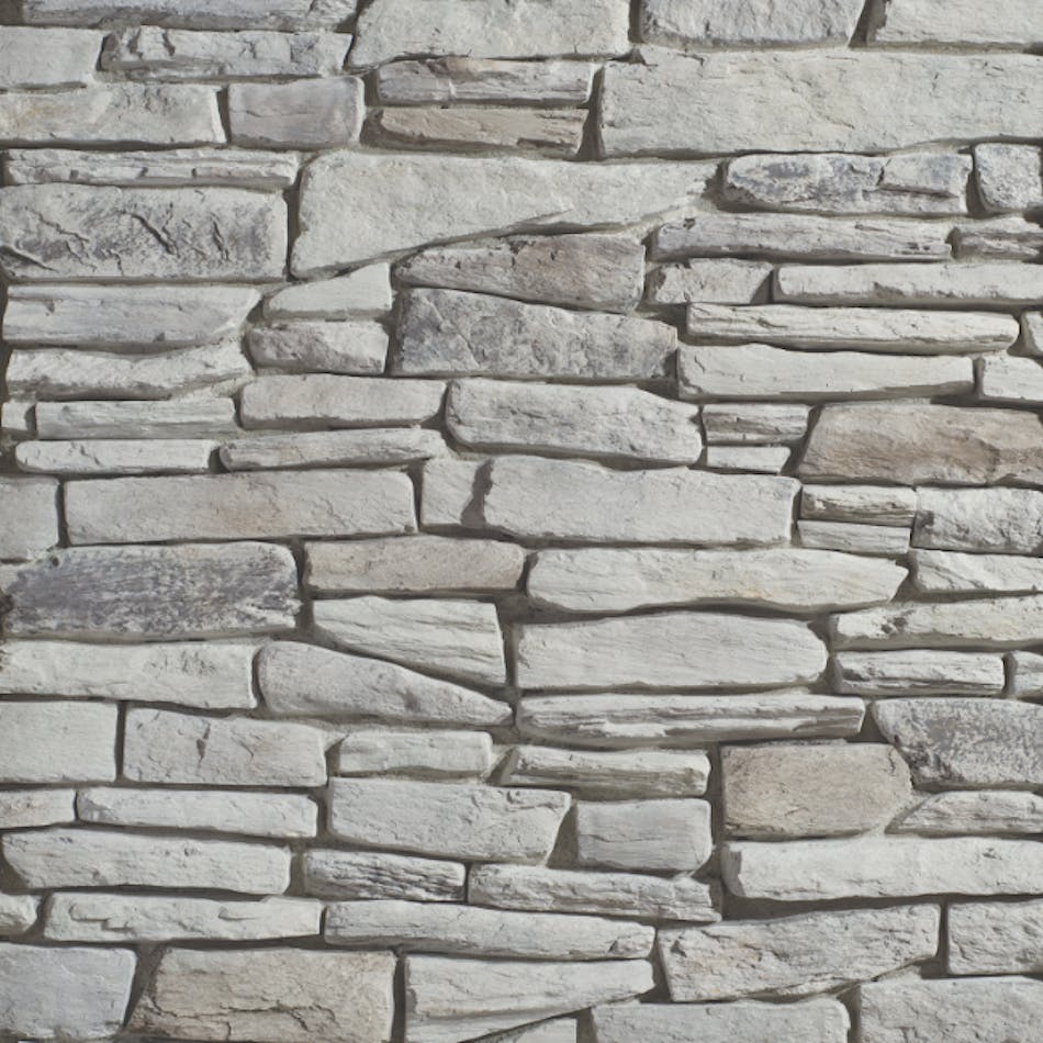 A stone veneer wall in various shades of gray mimicking stones with rugged coarse faces that cast shadows across the wall, featured here in Fogbank.