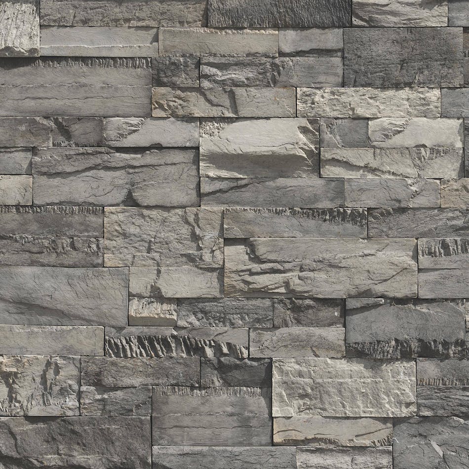 An image of a dark gray, chopped stone wall. The pieces of stone are a variety of different sizes.