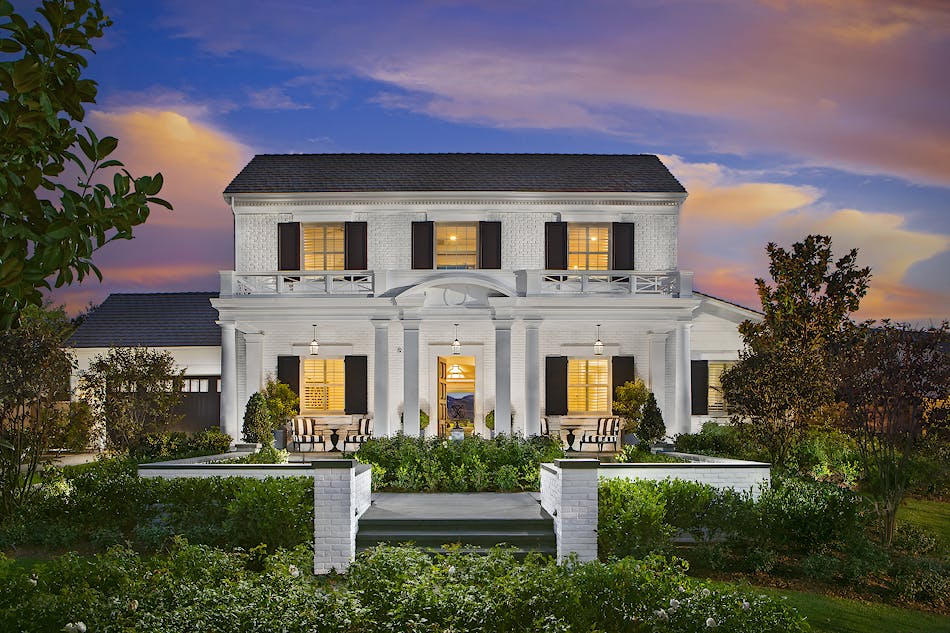 A two-story home featuring an extensive use of white painted brick and accented windows with black exterior shutters and black shingled roof creates a modern twist on this traditional design.
