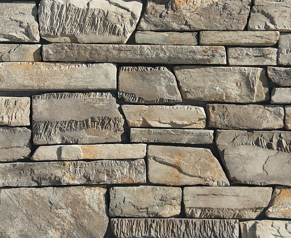 A stone veneer wall utilizing Craft Peak Ledge with rectilinear shapes and varying textures to create shadowplay, featured here in Greypearl.