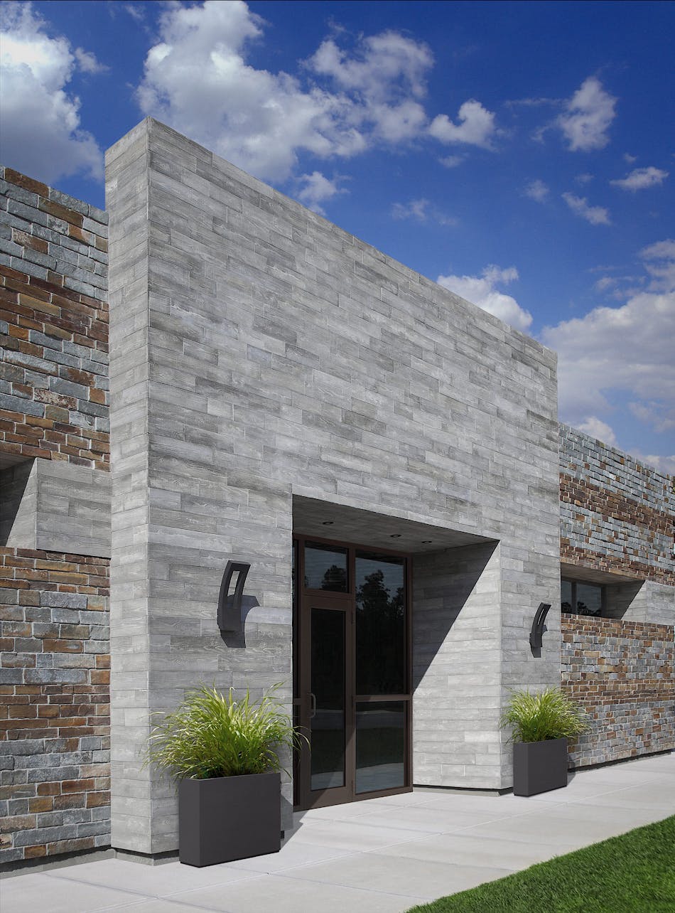 The entrance to this modern retail location features the unique board form aesthetic complimented by a natural stone wall.