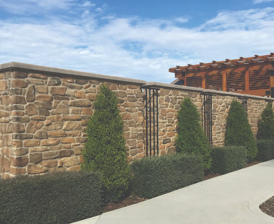 A feature stone wall creates a warm and timeless appeal to this country club entrance.