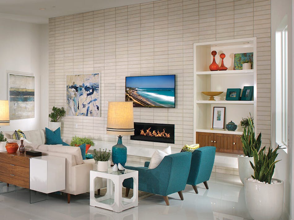 Living room with white and off-white brick veneer accent wall and brightly colored furniture, hanging art and decorations.